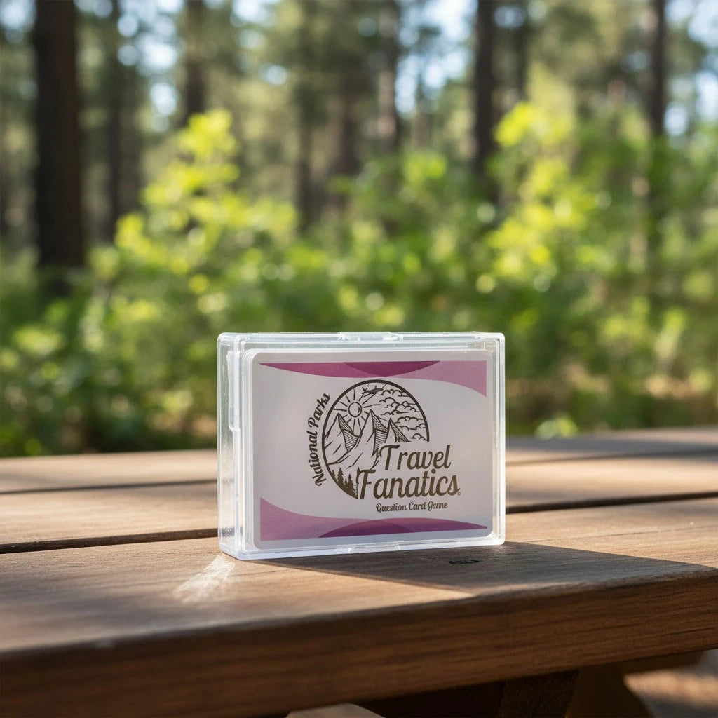 Card game box labeled 'Travel Fanatics' on a wooden table with a forest background