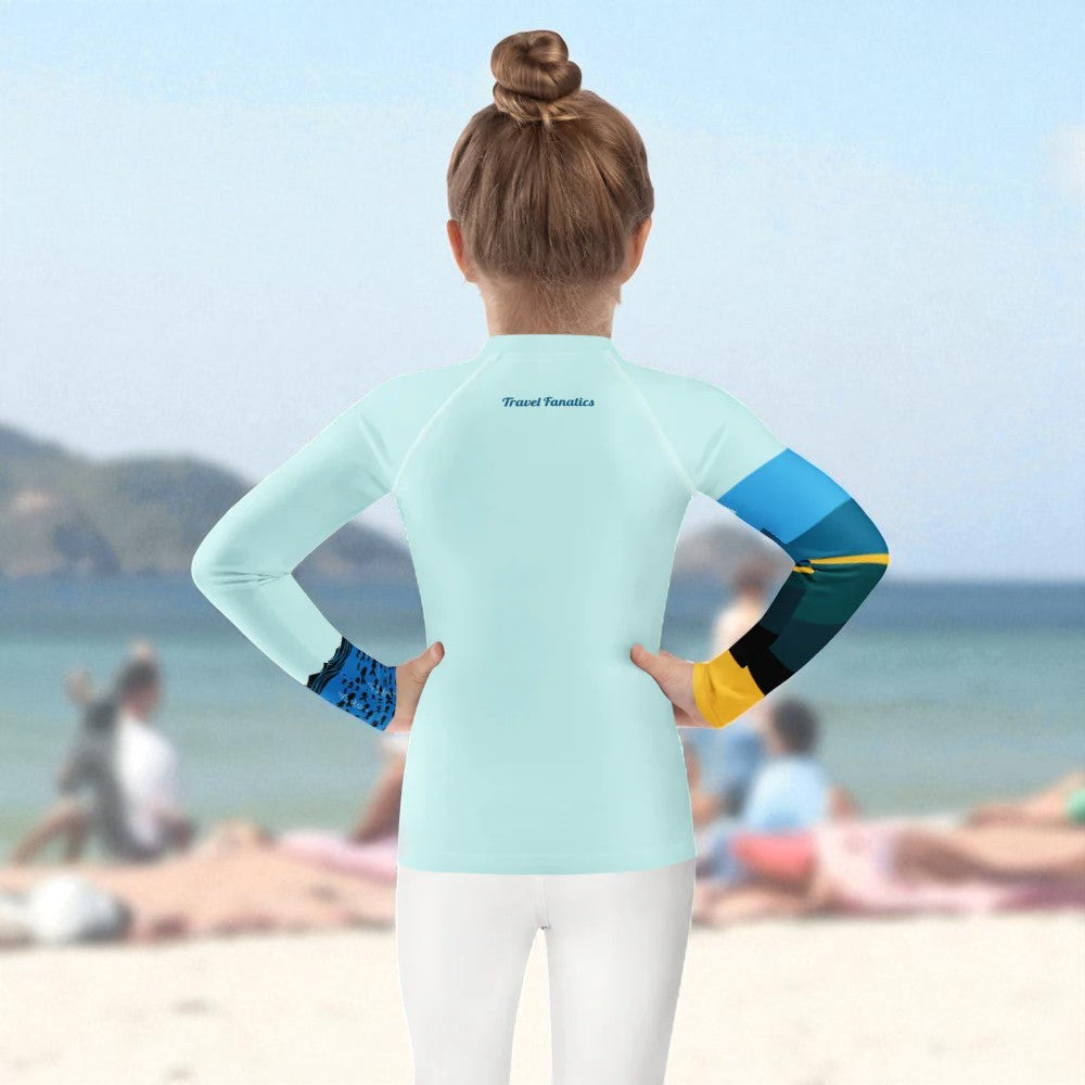Person wearing a colorful long-sleeve rash shirt on a beach