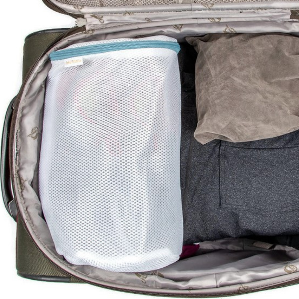 Close-up of bag in washing machine, soles visible, ensuring a thorough clean and reducing shoe damage.