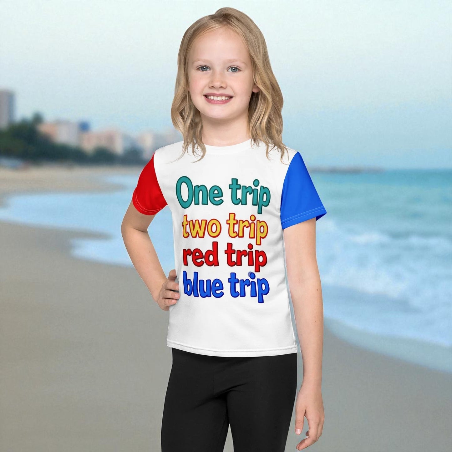 Child wearing a colorful t-shirt with text on a beach