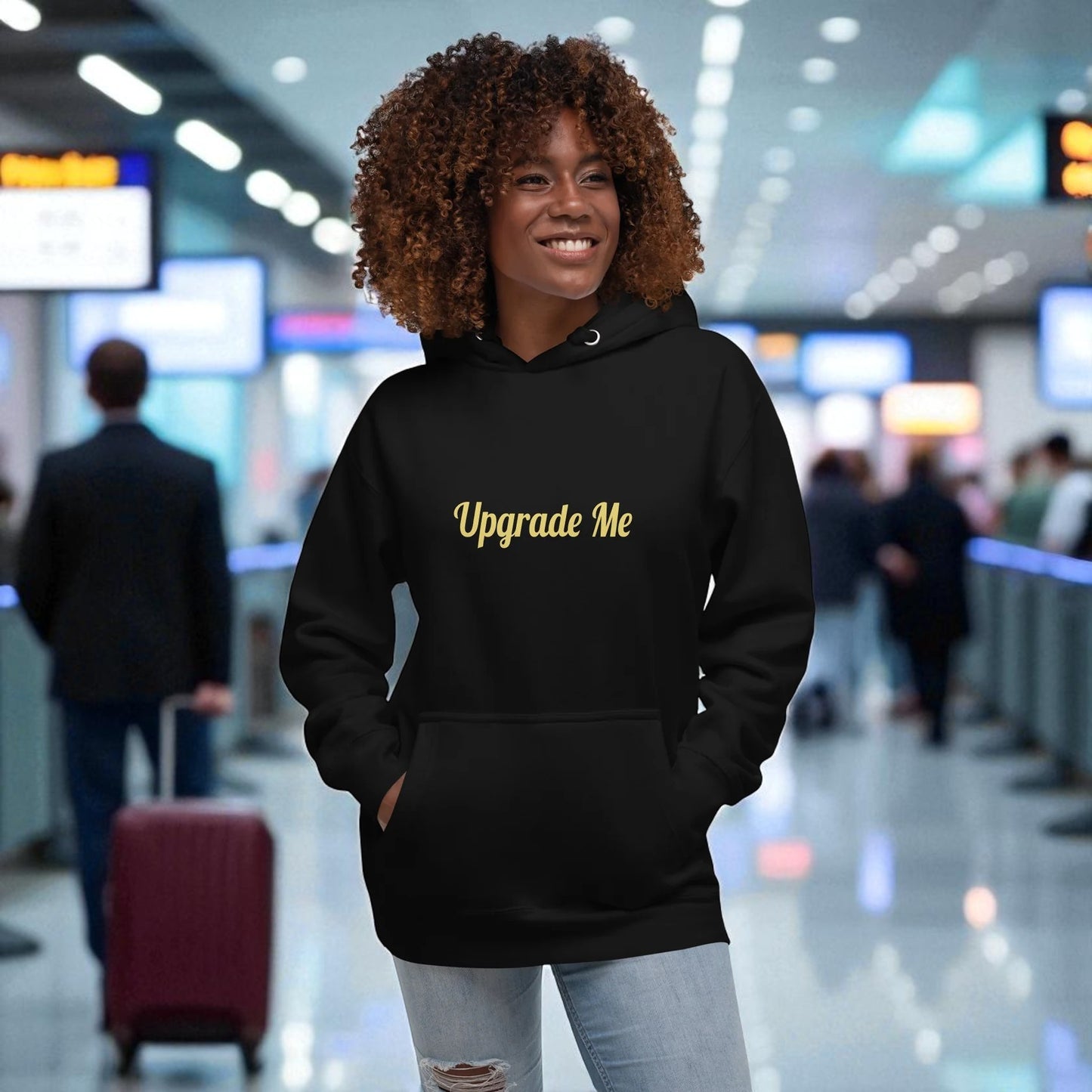 Person wearing a black hoodie with 'Upgrade Me' text in an airport setting