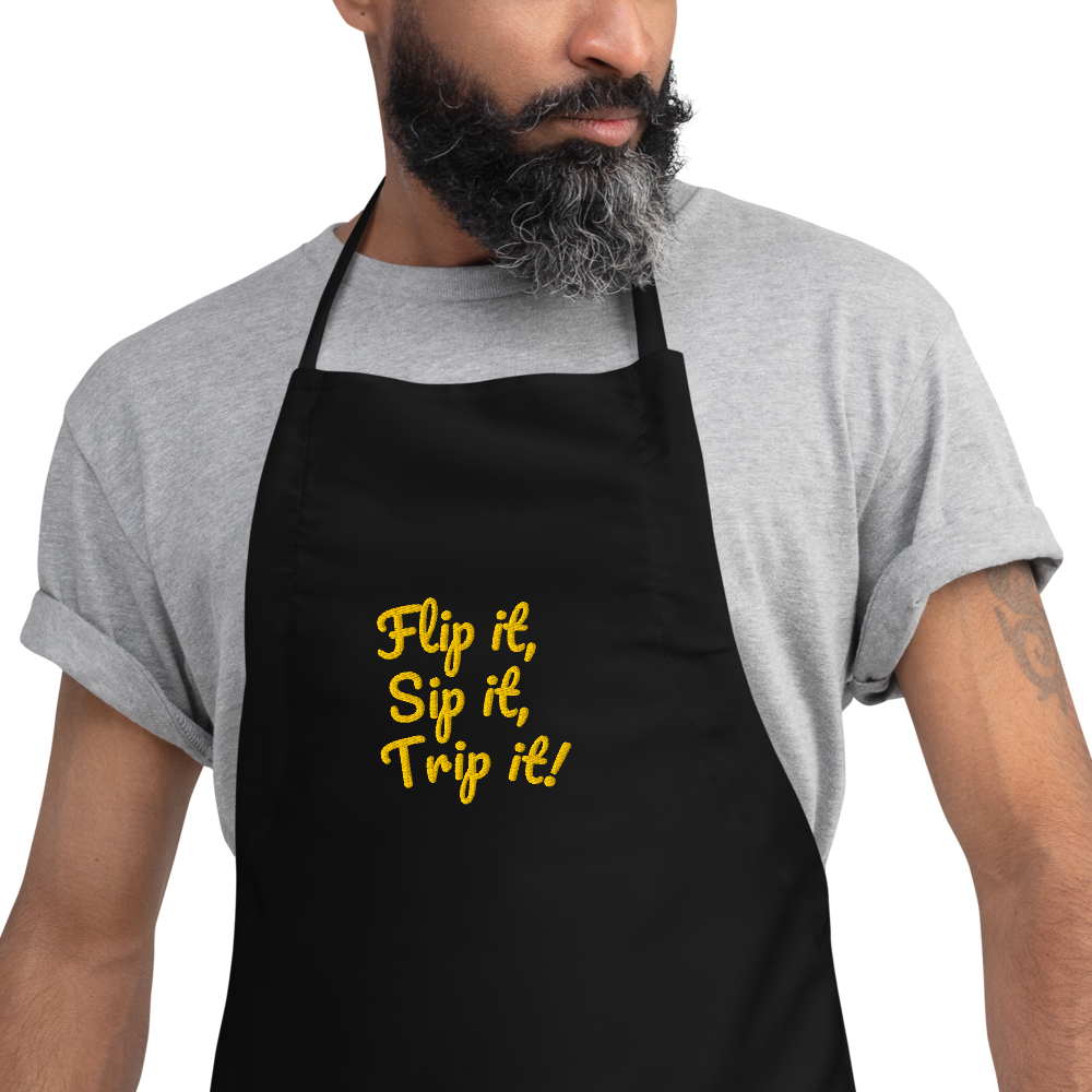 Man wearing a black apron with yellow text on a white background