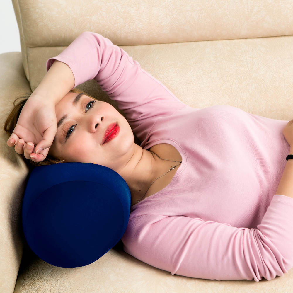 Woman lying on a couch with a blue micro bead pillow under her head
