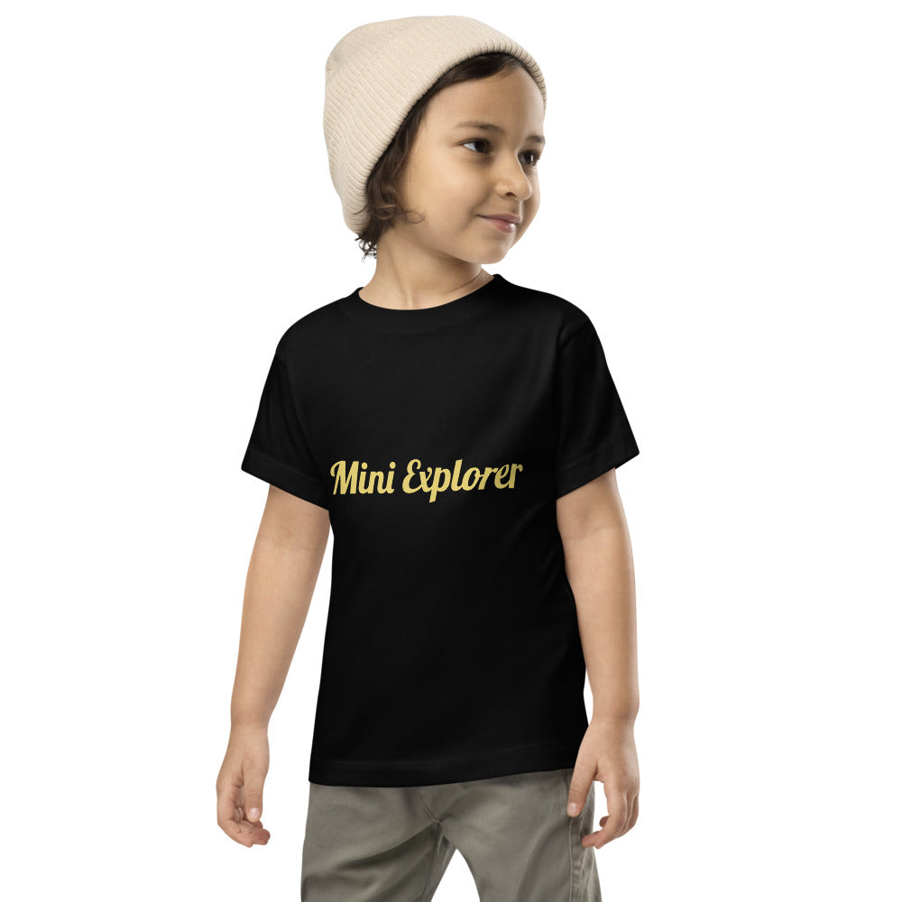 Child wearing a black t-shirt with 'Mini Explorer' text on a white background