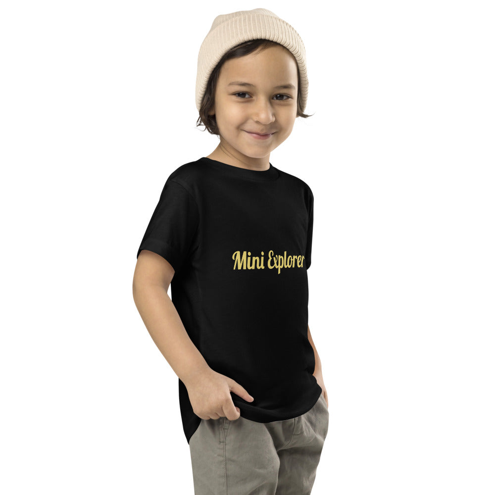 Child wearing a black t-shirt with 'Mini Explorer' text on a white background