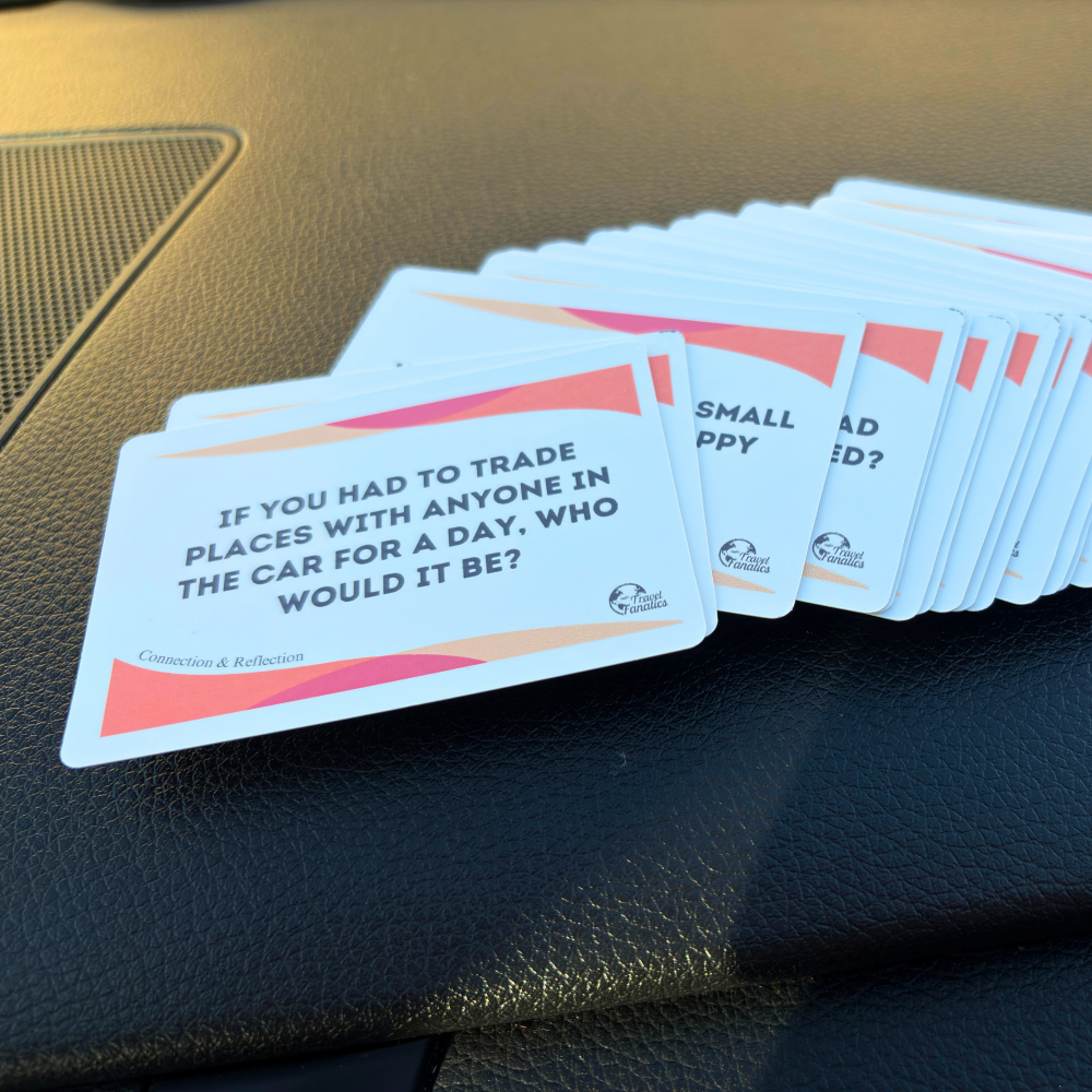 Stack of travel question cards on a car dashboard for road trip with family


