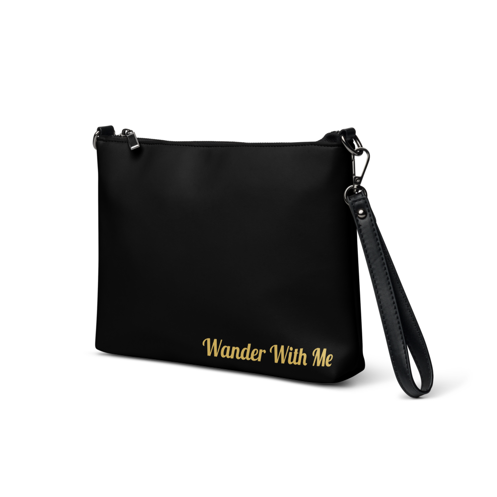 Black handbag with 'Wander With Me' text on a white background

