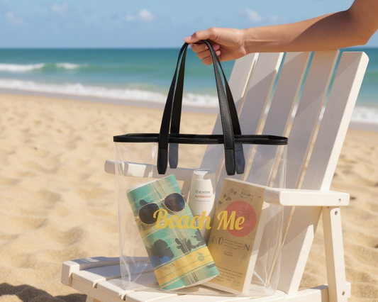 Clear beach bag with black handles on a white chair at the beach

