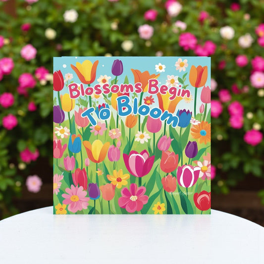 Children's book titled 'Blossoms Begin to Bloom' with colorful floral design on a white surface.

