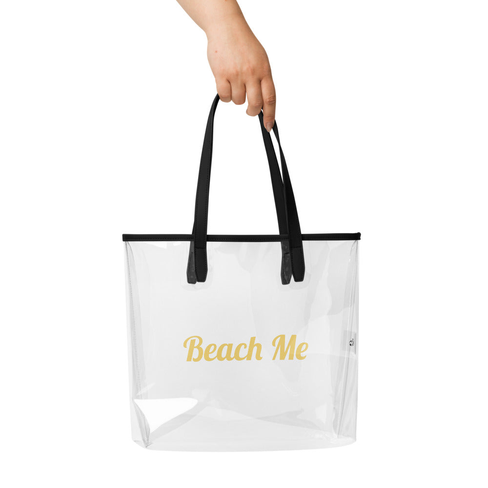Clear tote bag with black handles and 'Beach Me' text on a white background

