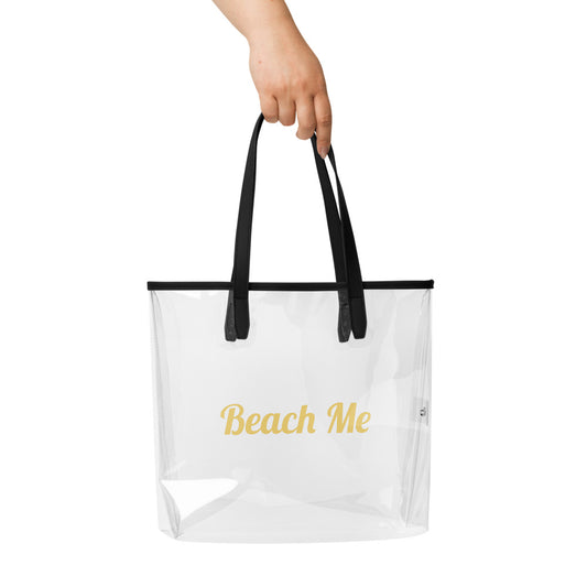 Clear tote bag with black handles and 'Beach Me' text on a white background

