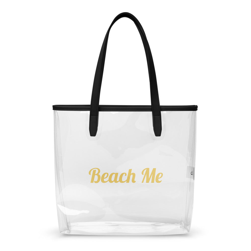 Clear tote bag with black handle and 'Beach Me' text in gold on a white background

