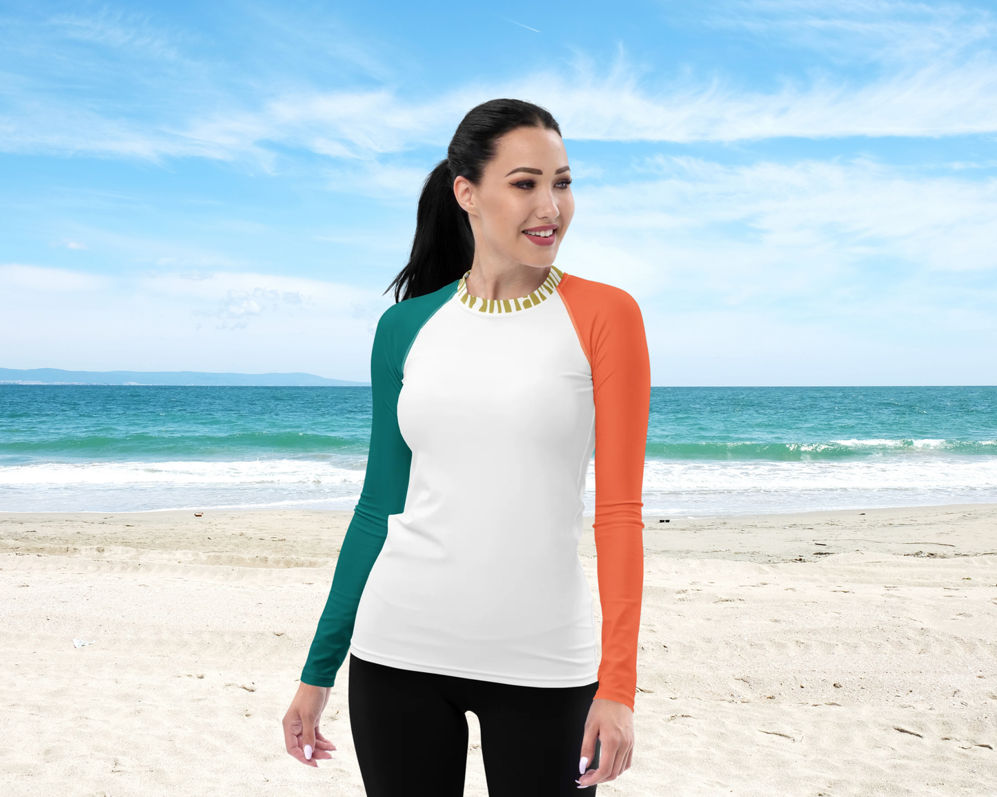 Woman wearing a colorful shirt on a beach with blue sky and ocean in the background

