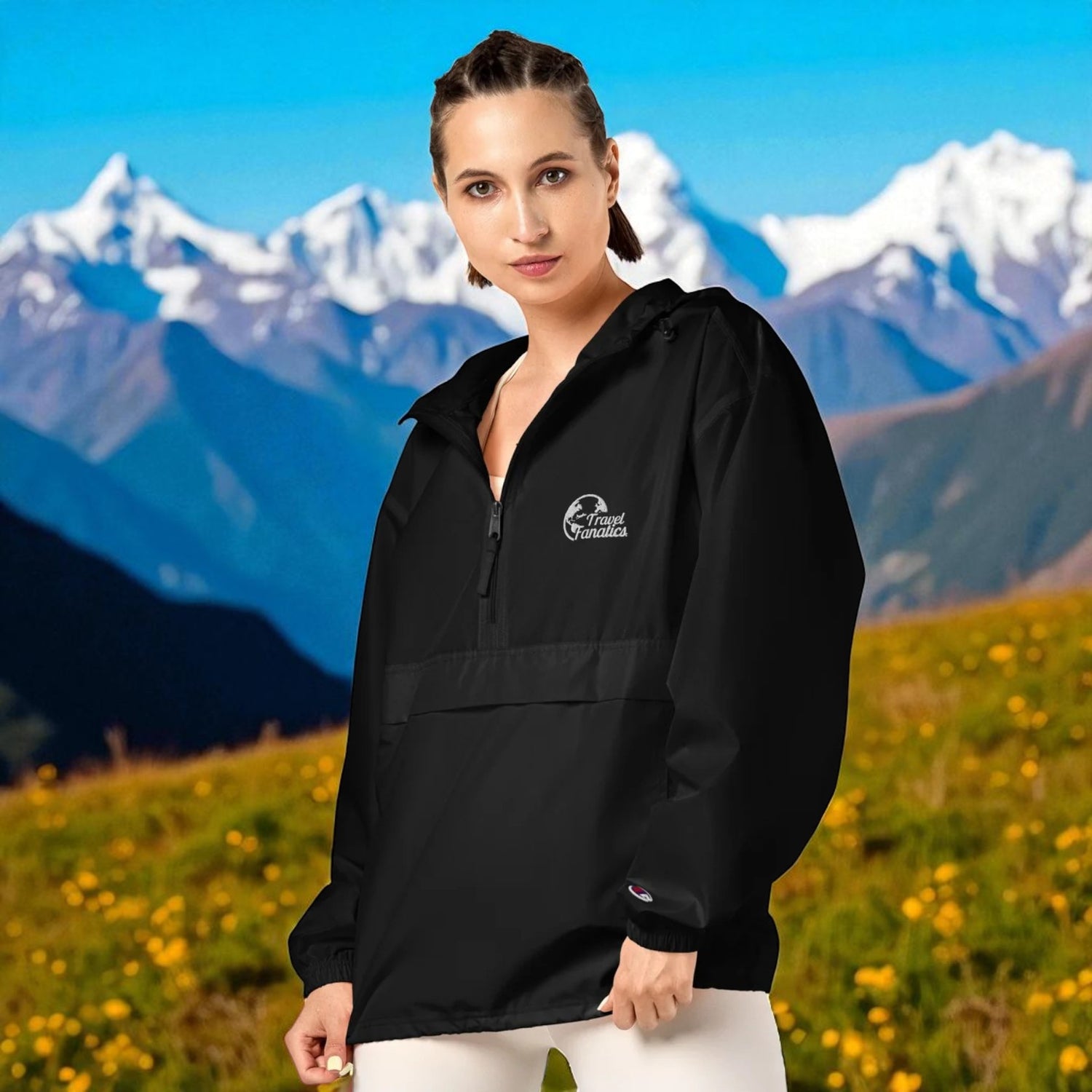 Woman wearing a black jacket with a logo in front of a mountainous landscape


