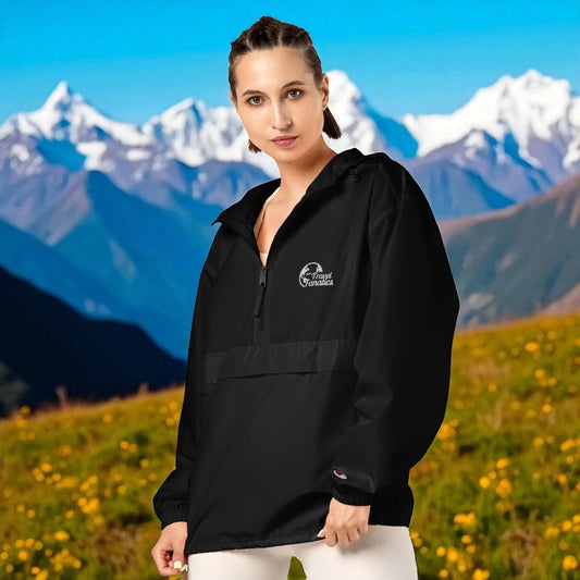 Woman wearing a black jacket with a logo in front of a mountainous landscape


