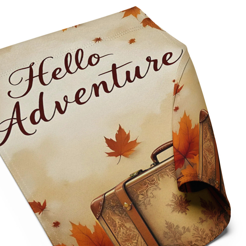 Tablecloth with 'Hello Adventure' text, suitcase, and autumn leaves on a beige background

