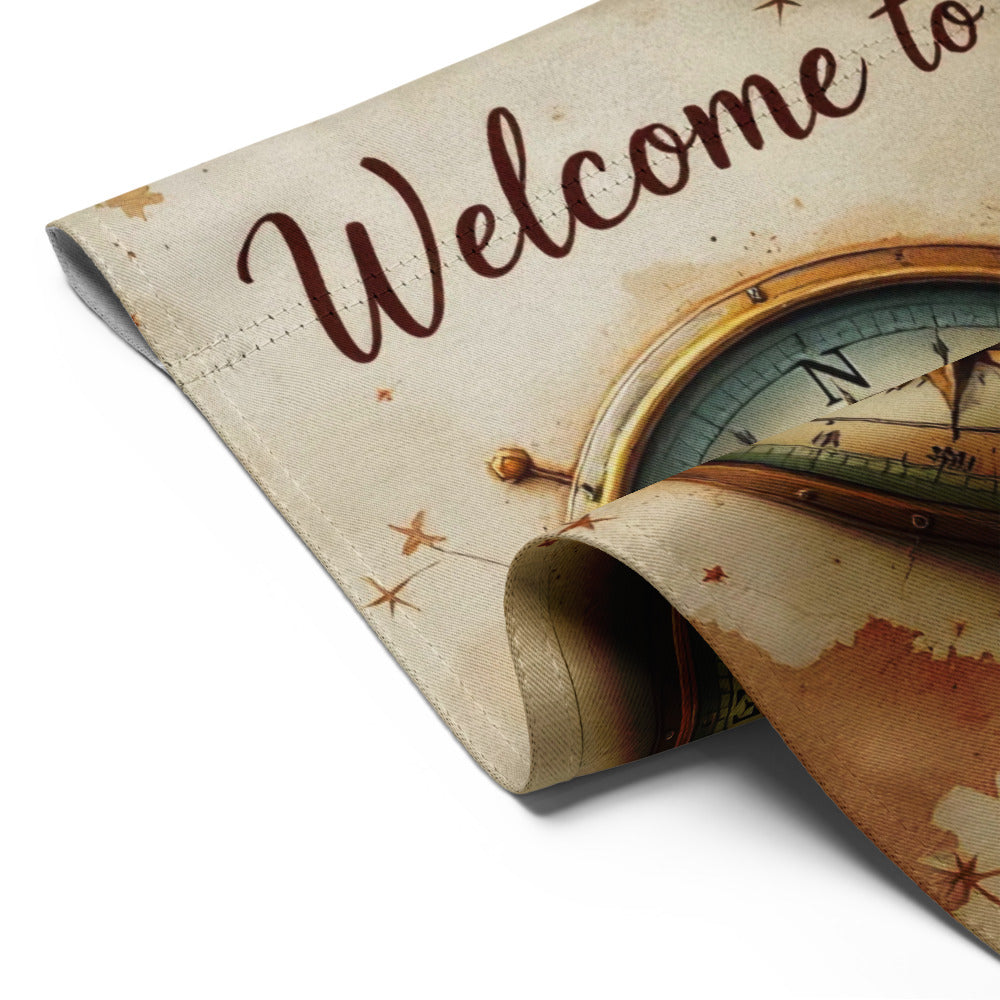 Decorative mat with compass design and 'Welcome to' text on a beige background
