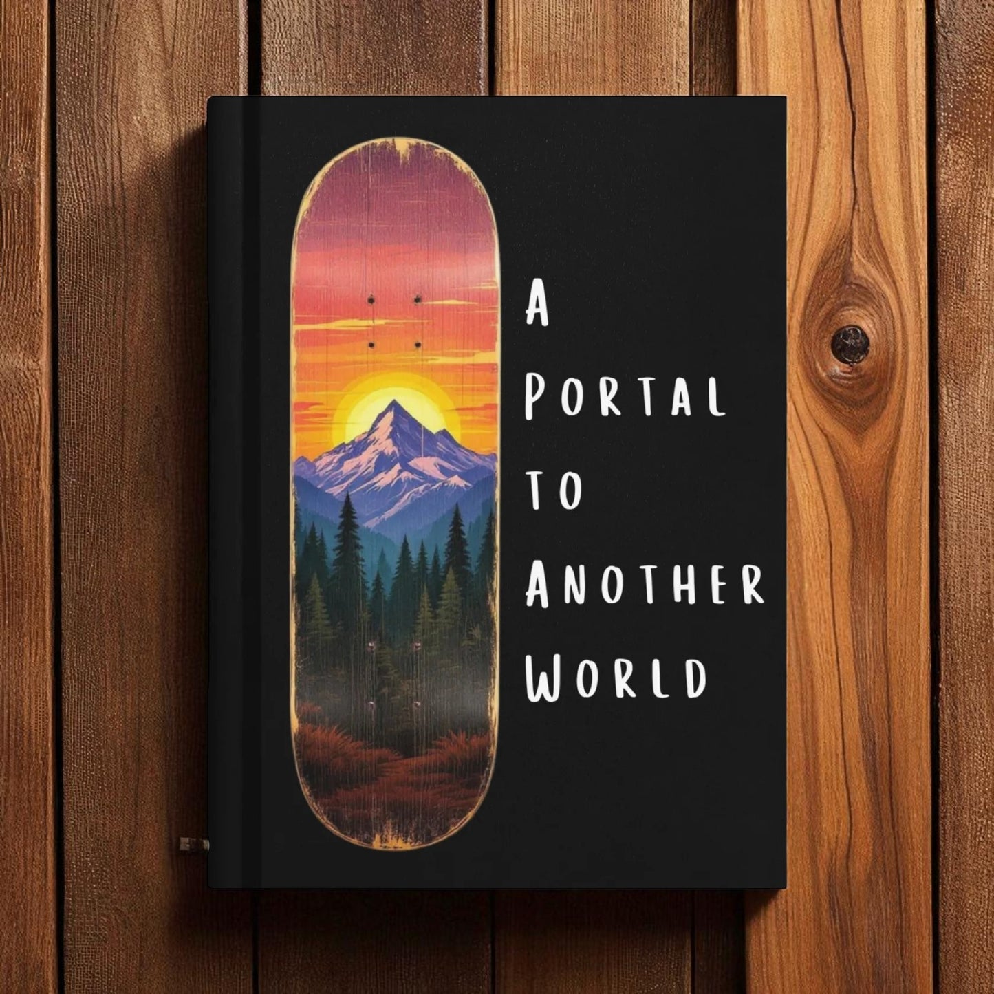 Skateboard deck with mountain and forest design on a black background with text 'A Portal to Another World' against a wooden background.

