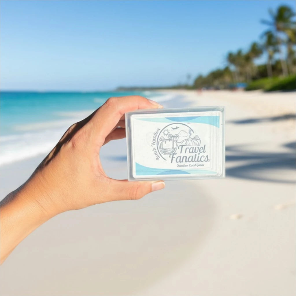 Hand holding a card with 'Travel Fanatics' logo on a beach background

