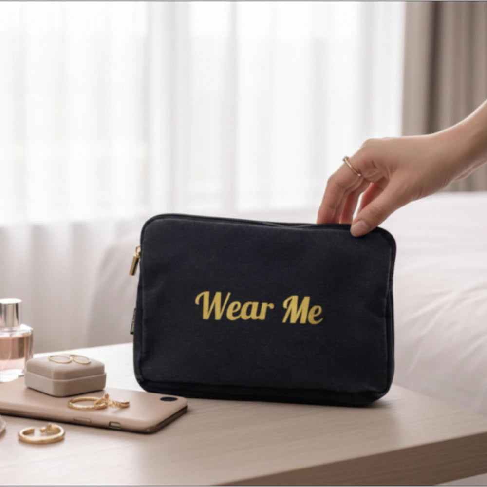 Wear Me travel laundry bag on bedside table with personal items, showing compact size and premium fabric design