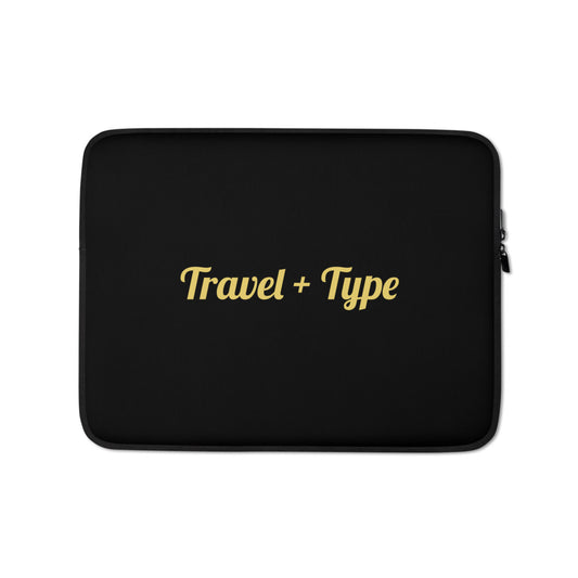 Black laptop sleeve with 'Travel + Type' text in gold on a white background

