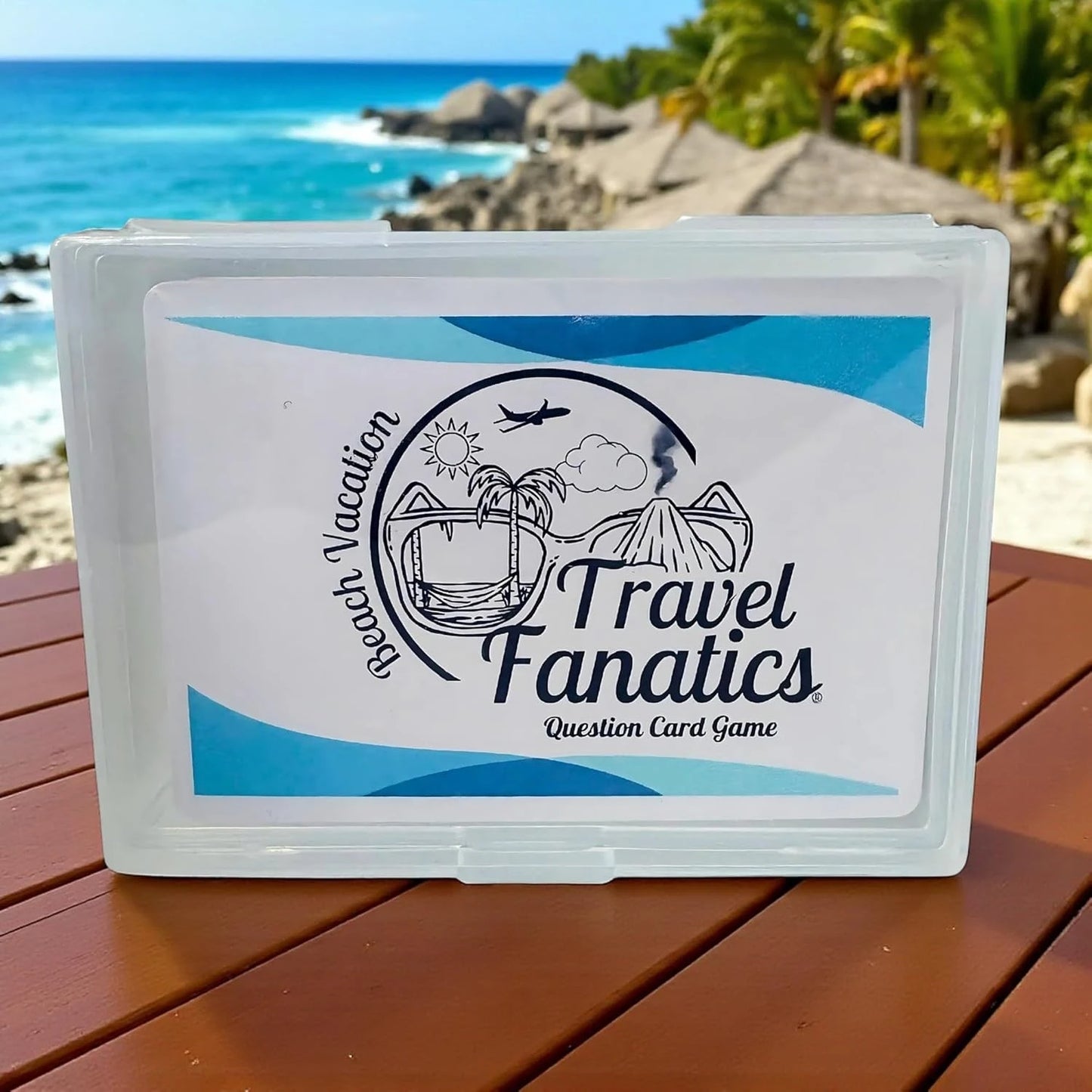 Travel Fanatics question card game box on a wooden table with a beach background

