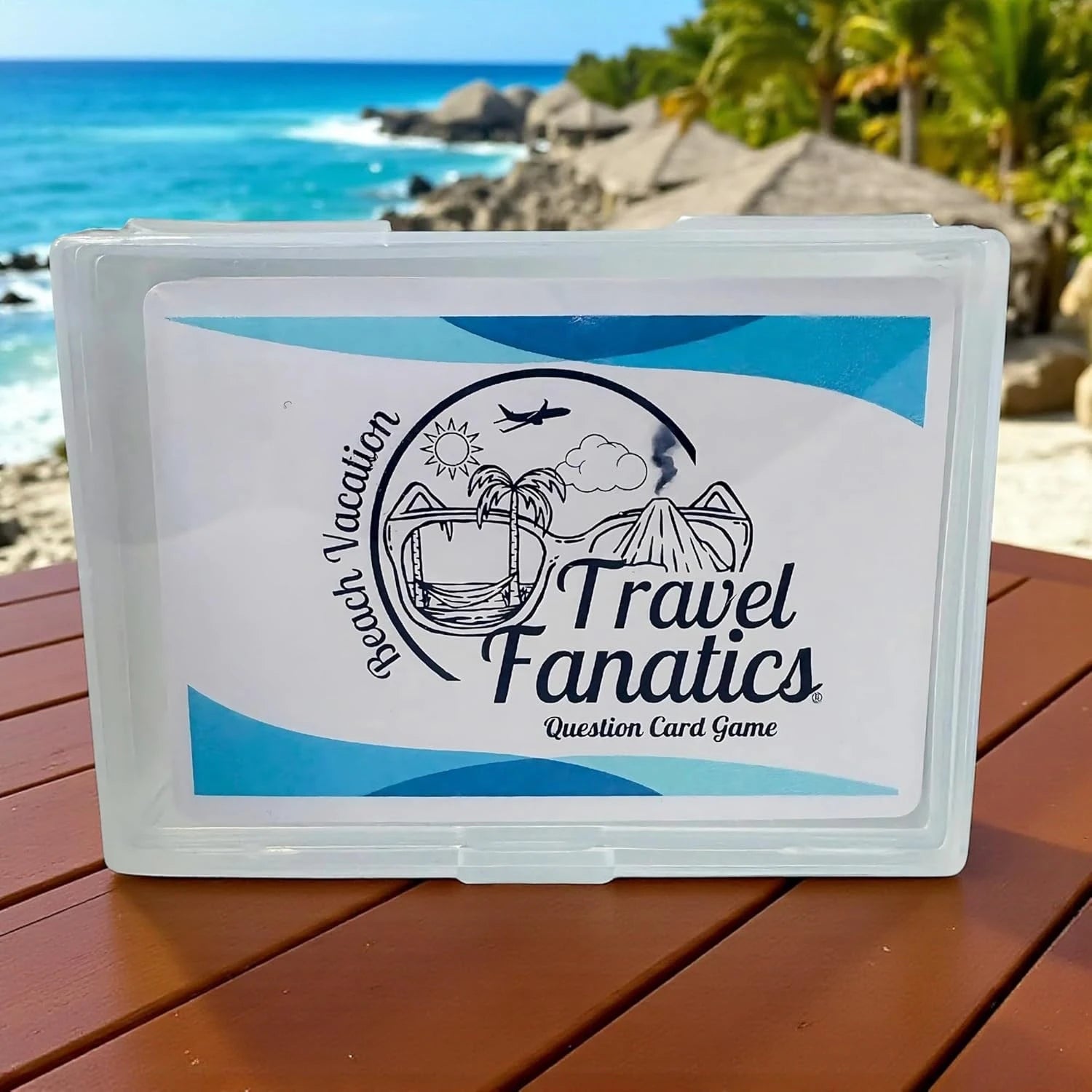 Travel Fanatics question card game box on a wooden table with a beach background


